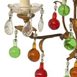 Lustrous chandelier with two wall lights decorated with foliage and pendants.