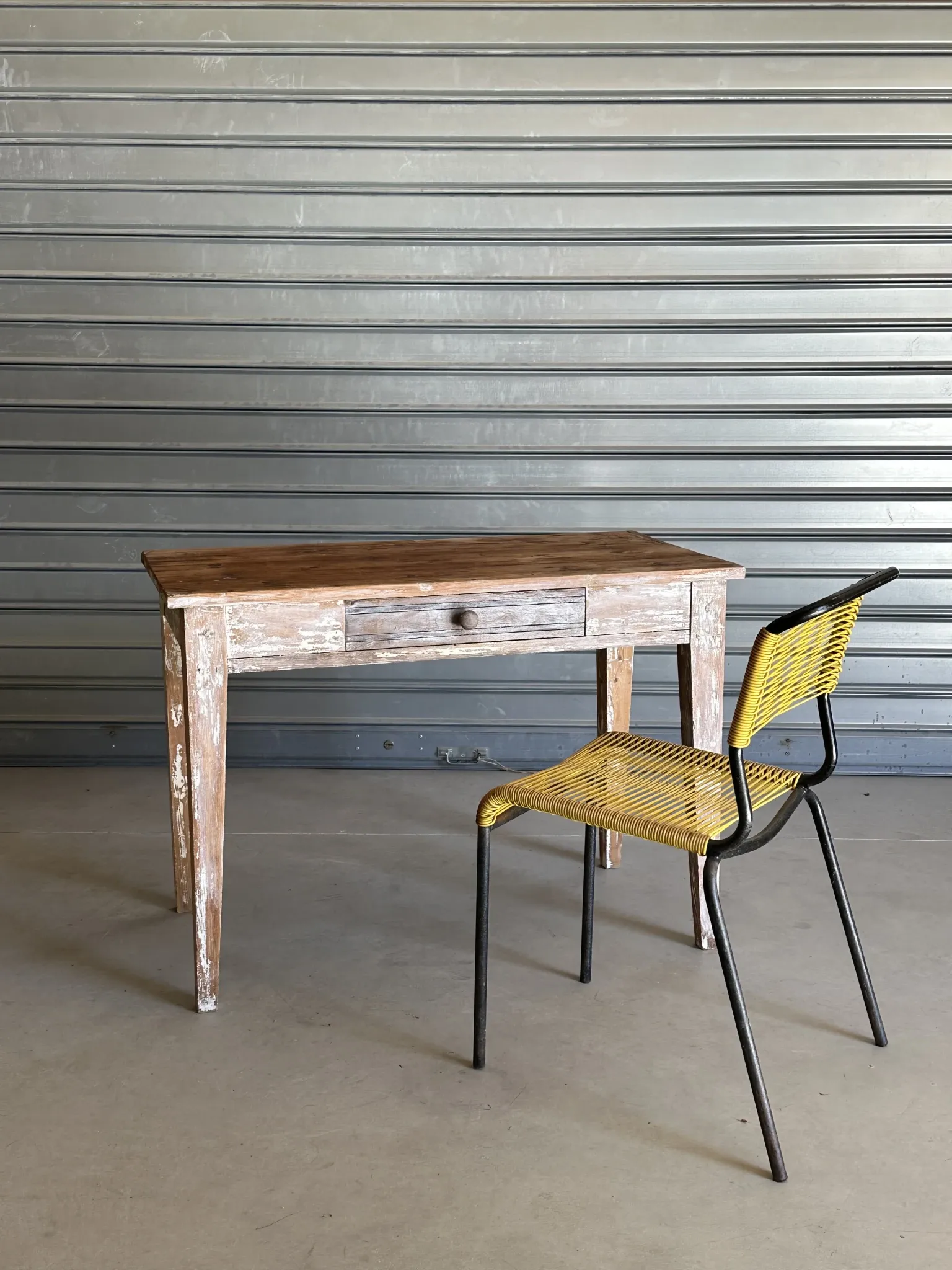 Vintage table made of raw wood with a distressed white base.