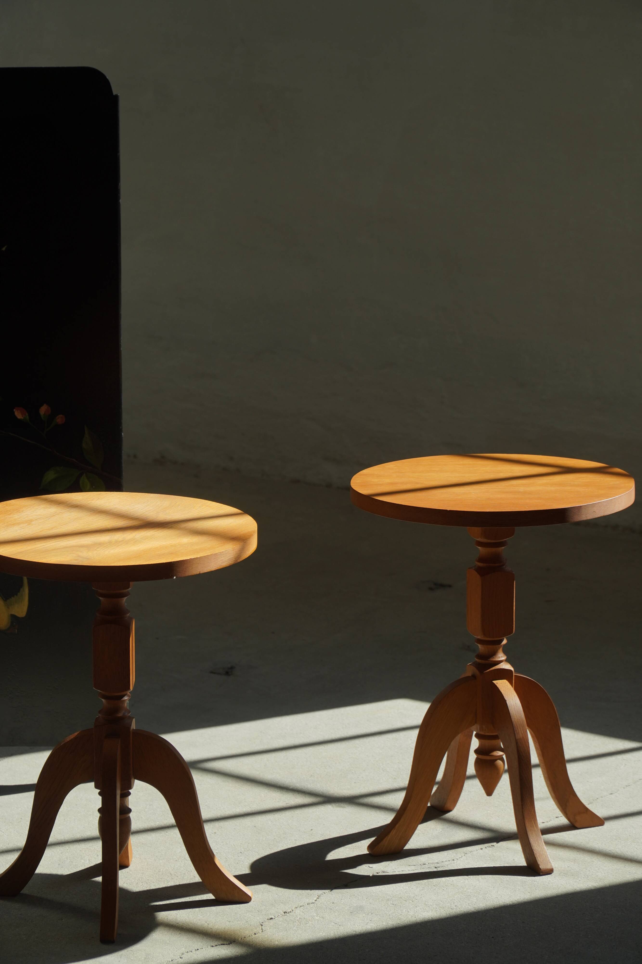 Pair of Scandinavian oak side tables with central legs and sculptural curved feet, 1960s.
