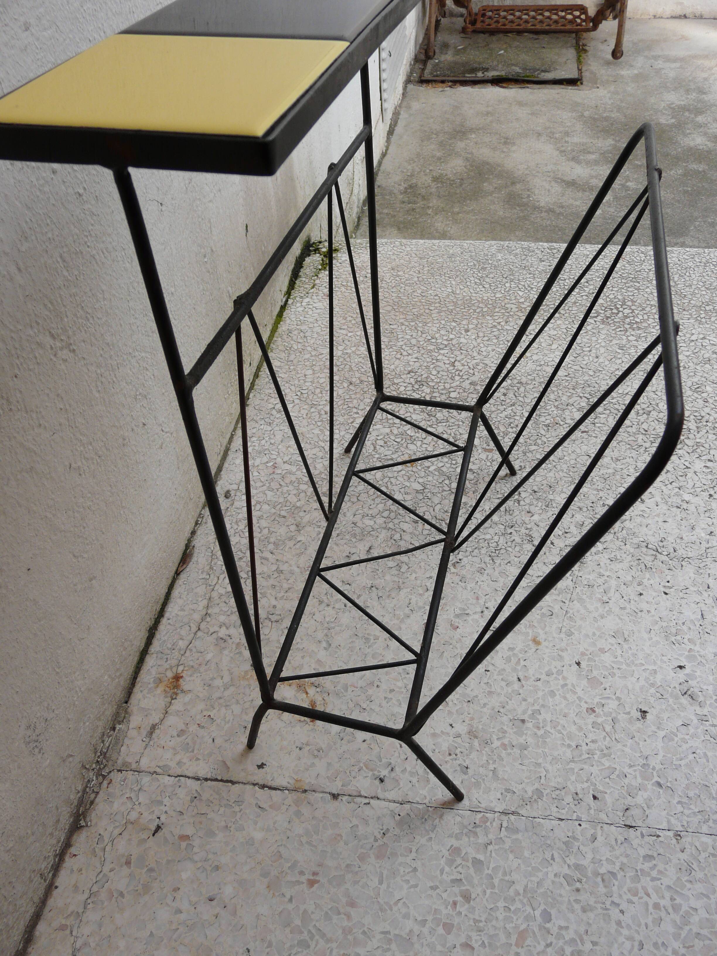Black metal magazine rack and yellow and black tiled shelf.