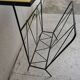 Black metal magazine rack and yellow and black tiled shelf.