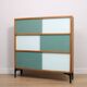 A vintage mid-century 3 tiered bookcase with glass sliding doors