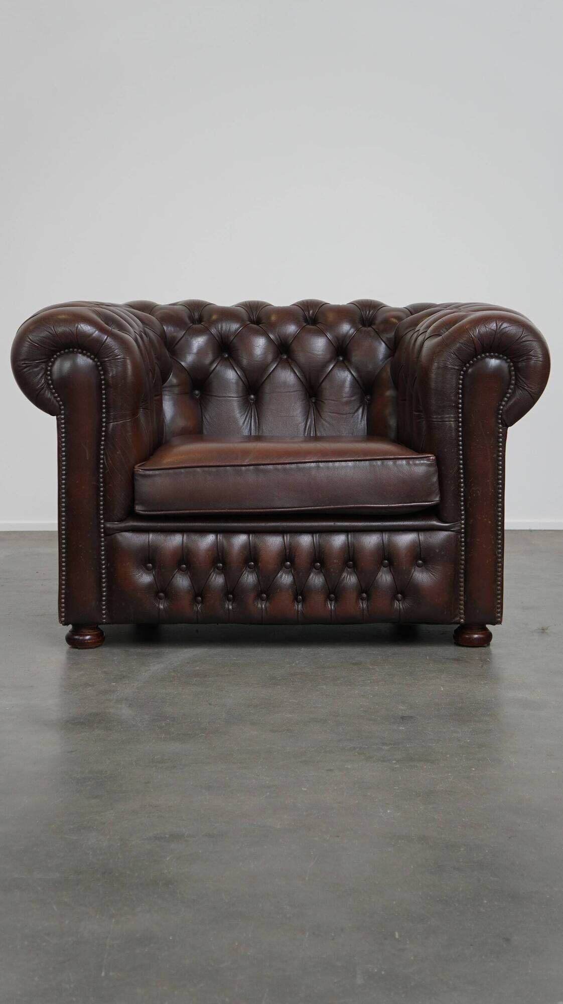 Beautiful and spacious dark brown mottled English cow leather Chesterfield armchair