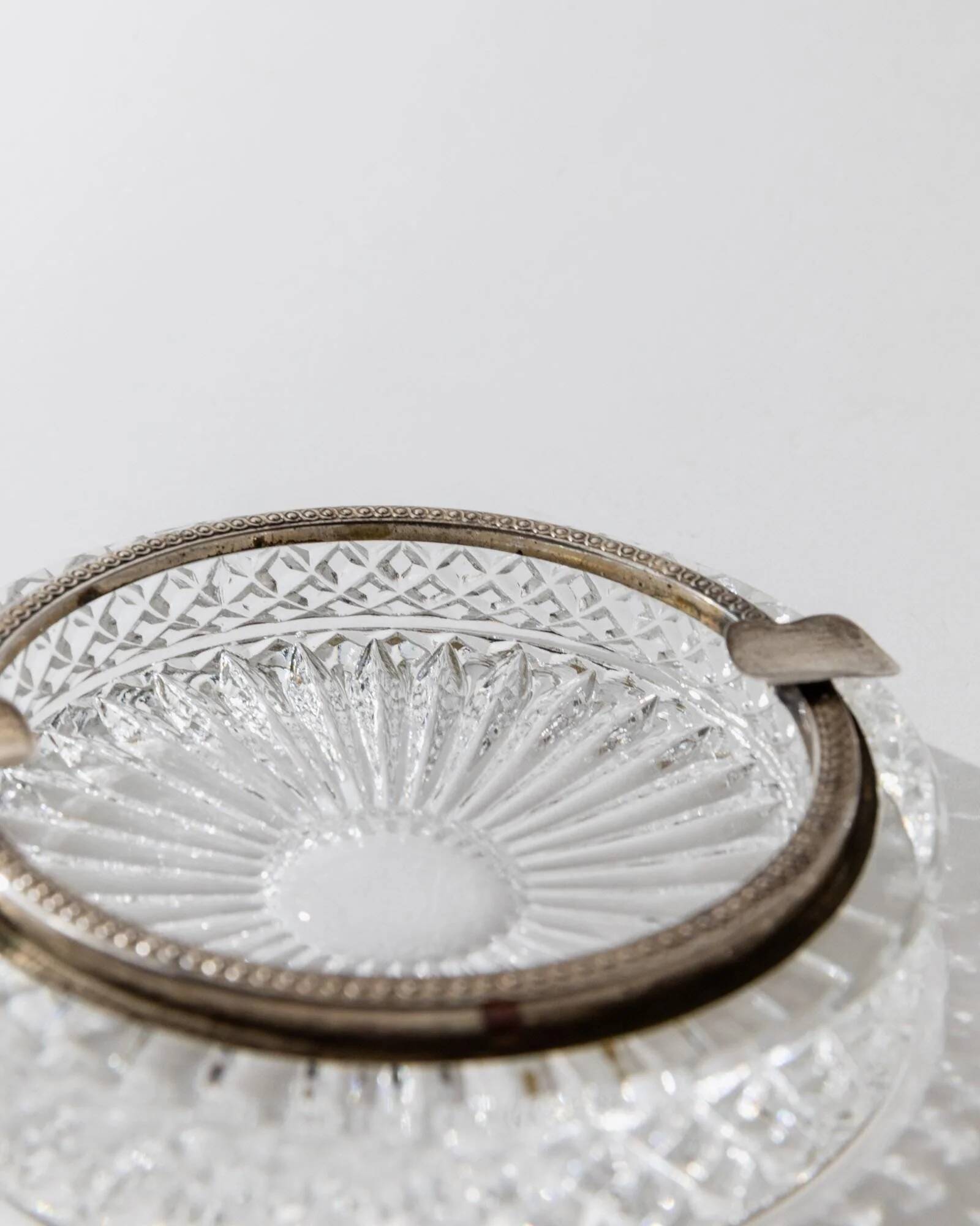 Vintage crystal glass ashtray from the 1920s, silver-edged with a textured pattern, Art Deco table decoration.