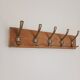 Wall-mounted coat rack with 5 vintage-style hooks in patinated wood and metal.