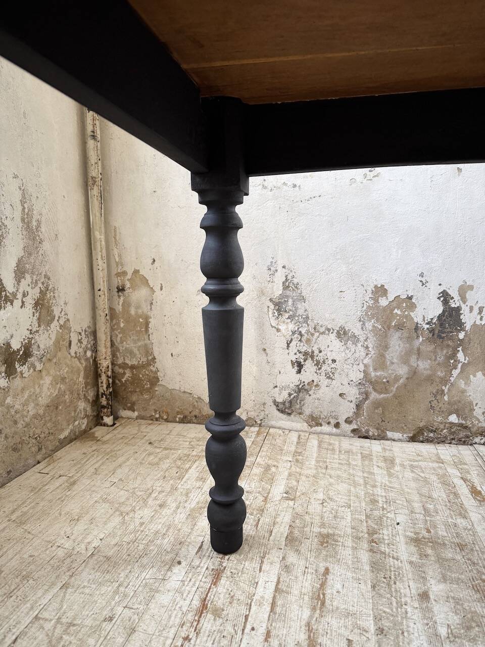 Oak farmhouse table with turned black legs.