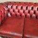 Three-seater curved red leather chesterfield sofa