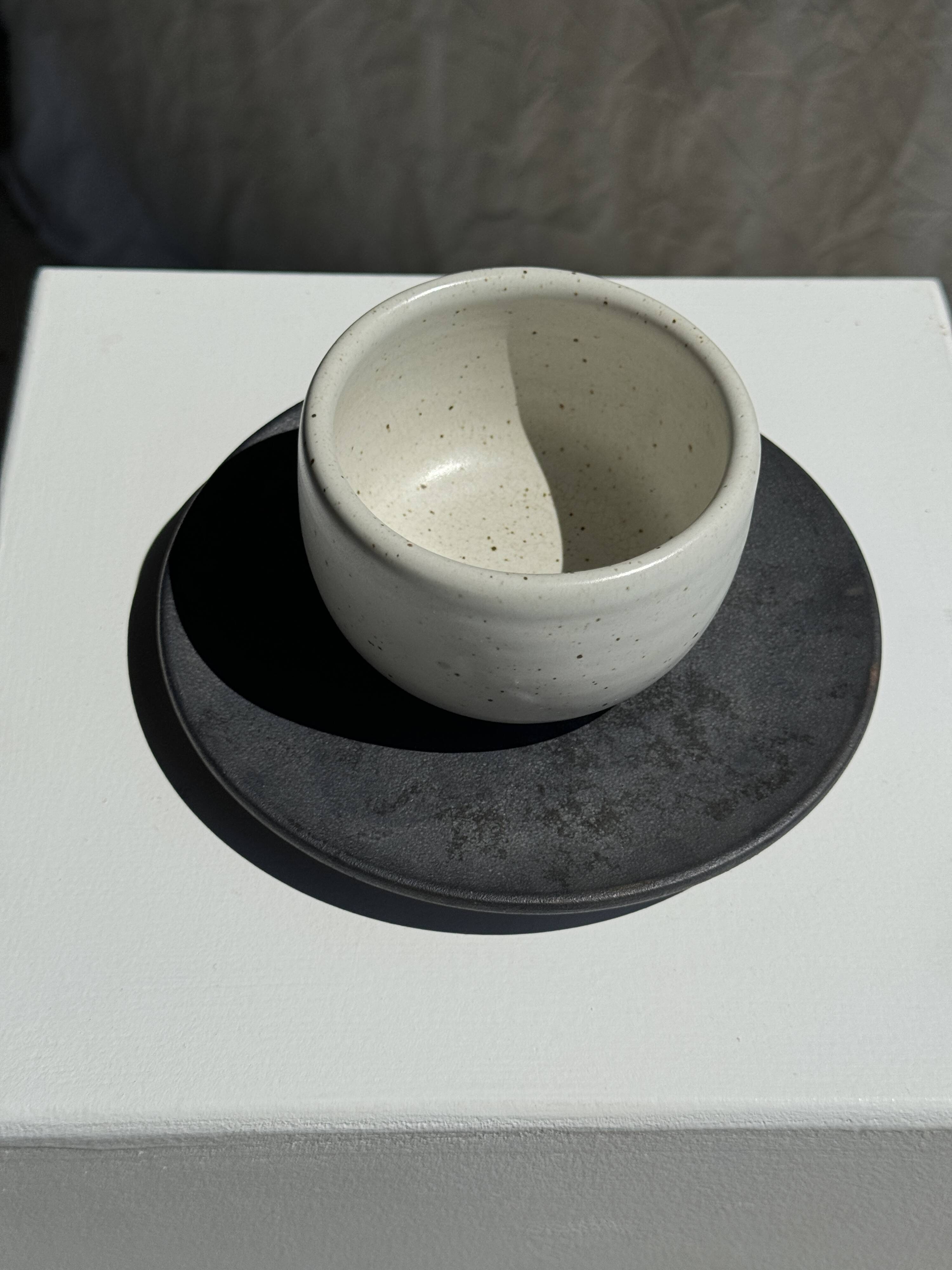White Indonesian ceramic cup and gray saucer