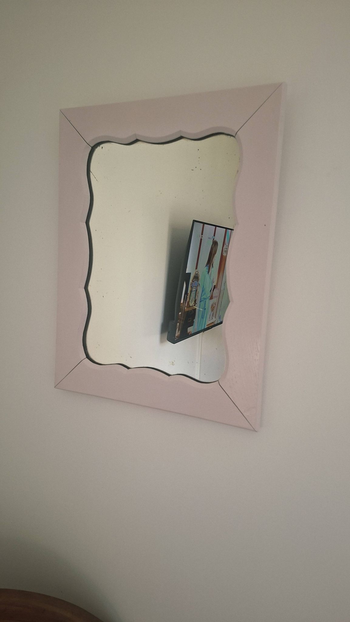 Mid-20th century rectangular wall mirror with a powder pink frame.