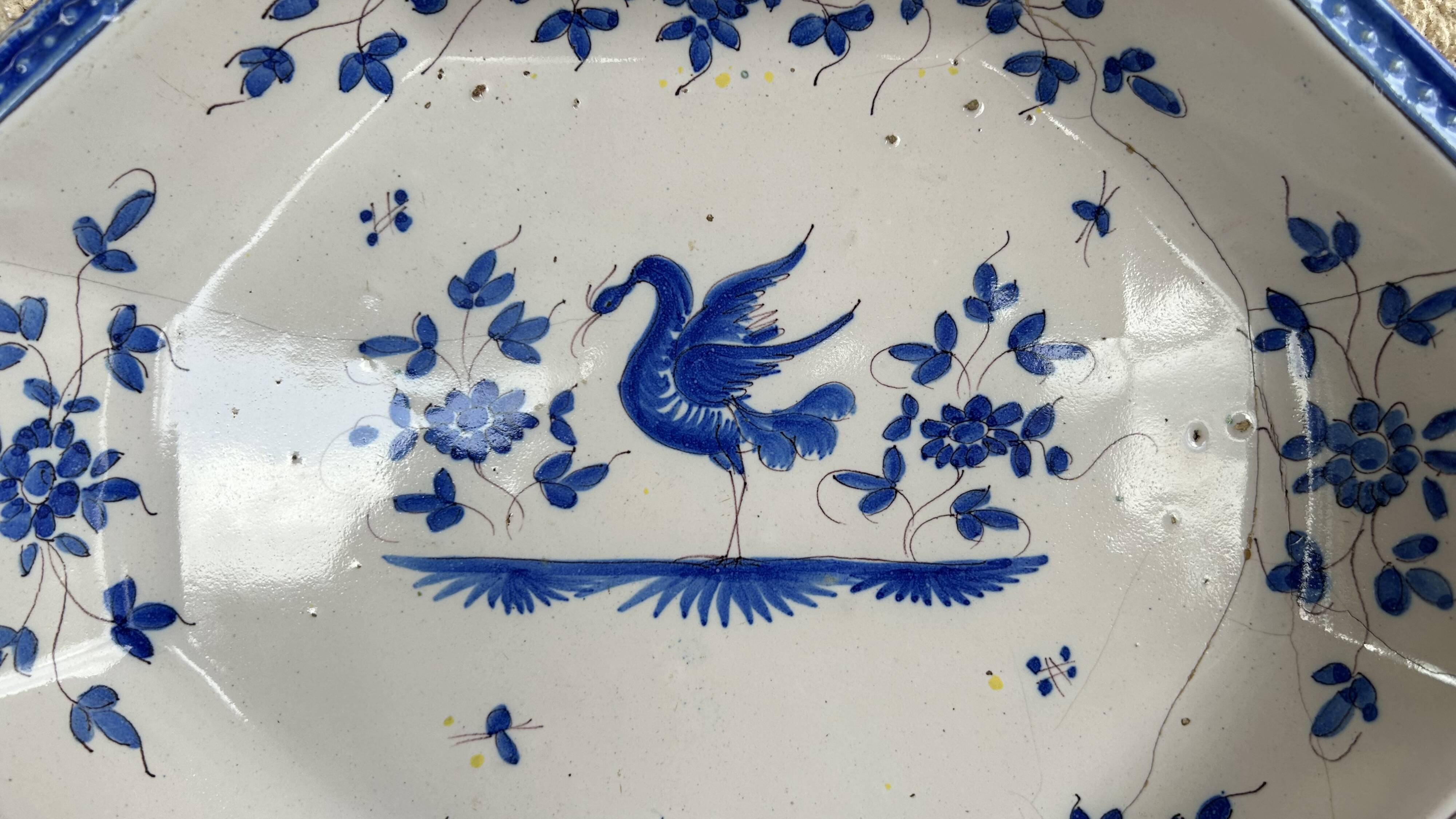 Antique octagonal plate in blue and white pottery with bird decoration.