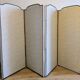 Vintage white faux leather screen with four studded panels, elegant decor.