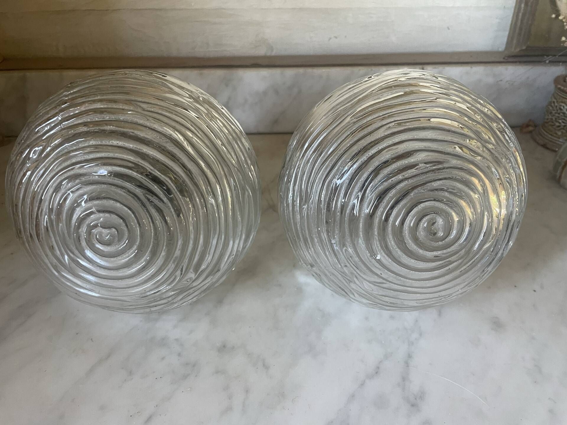 Pair of neoclassical wall sconces in twisted brass and ribbed glass.