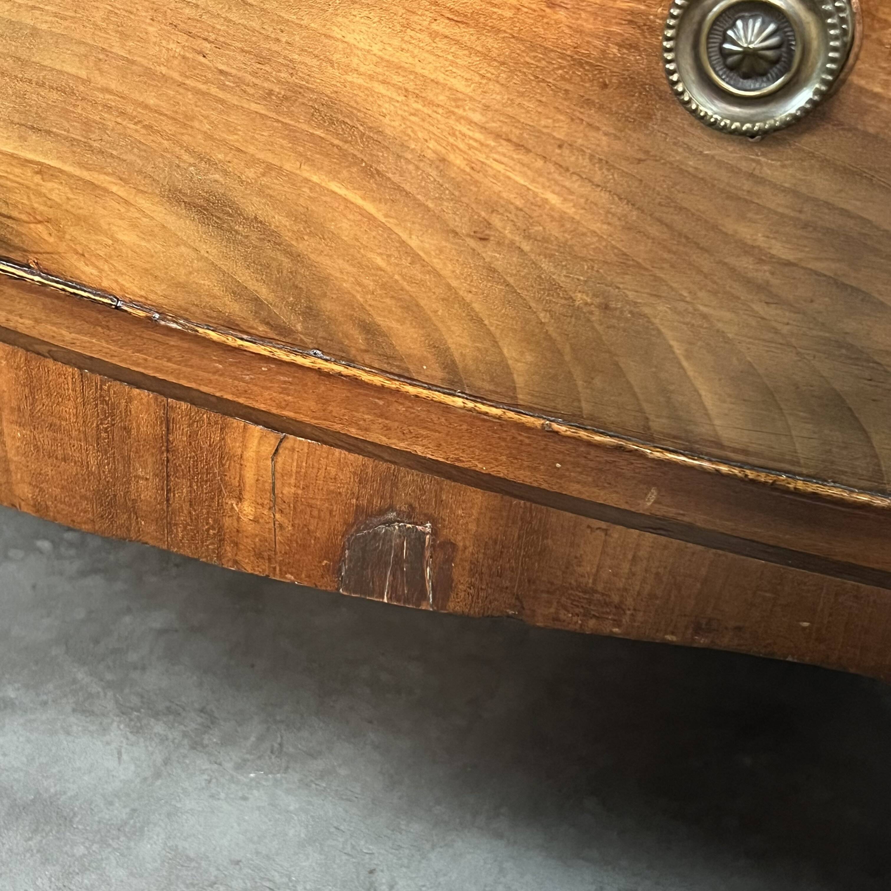 English commode from the George III Regency period, bombe shape in mahogany veneer.