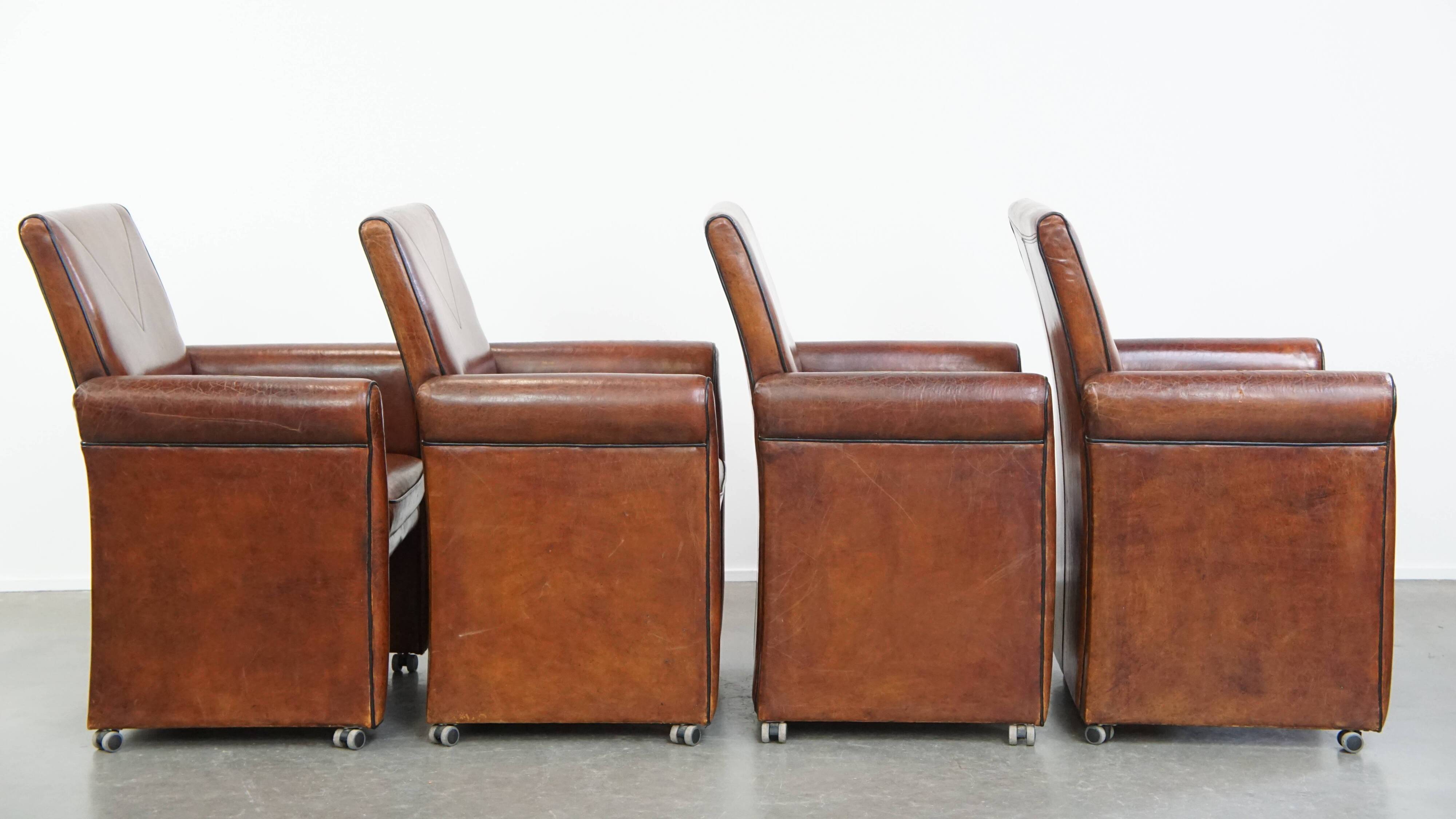 Vintage set of 4 sheepskin leather dining chairs on castors