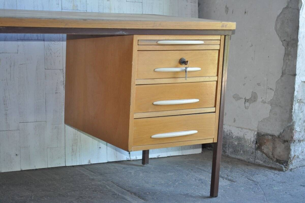 Mid-century Hungarian brown wooden desk with symmetrical drawers and white handles.