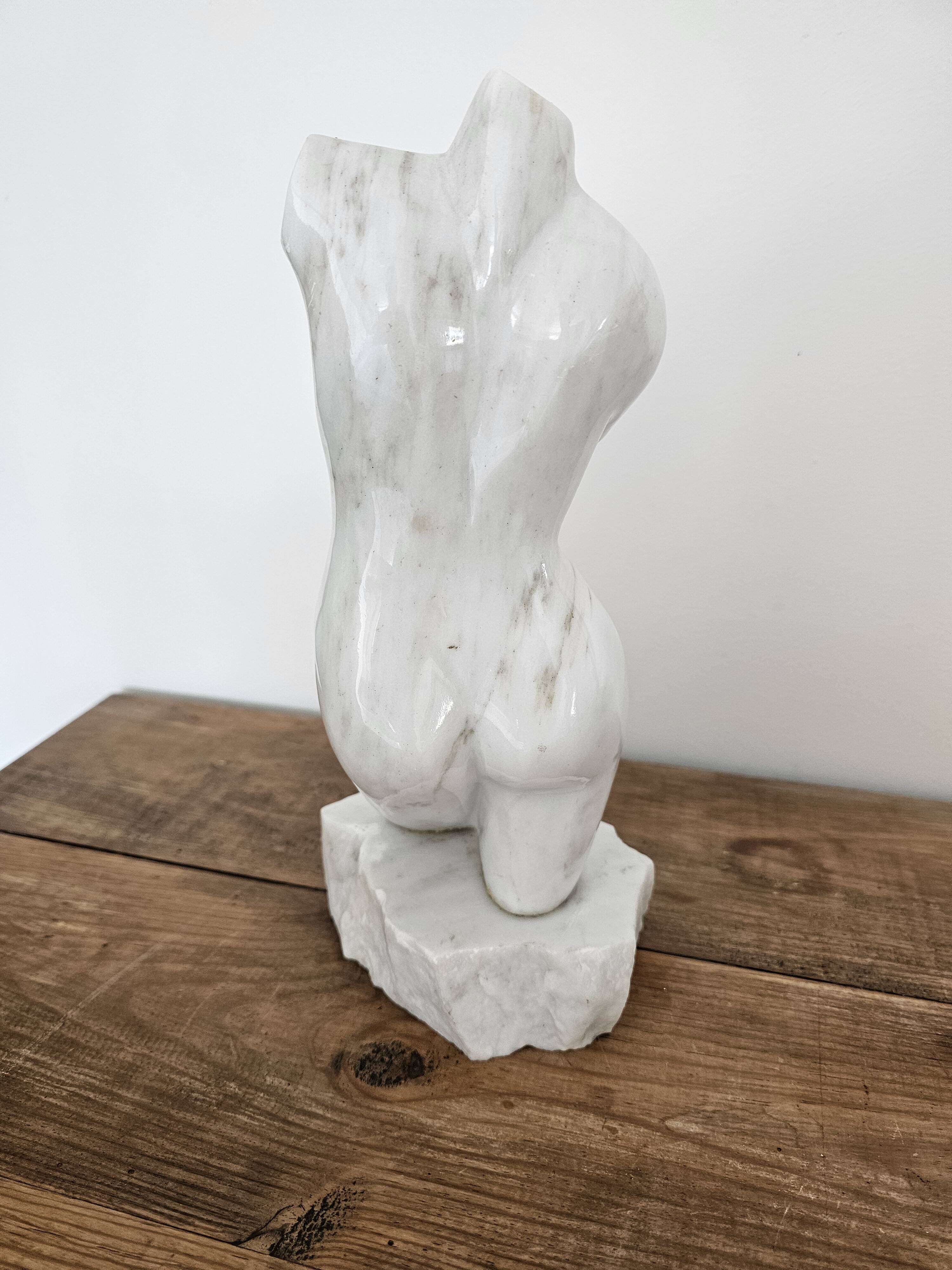 Sculpture of a female torso in white marble.