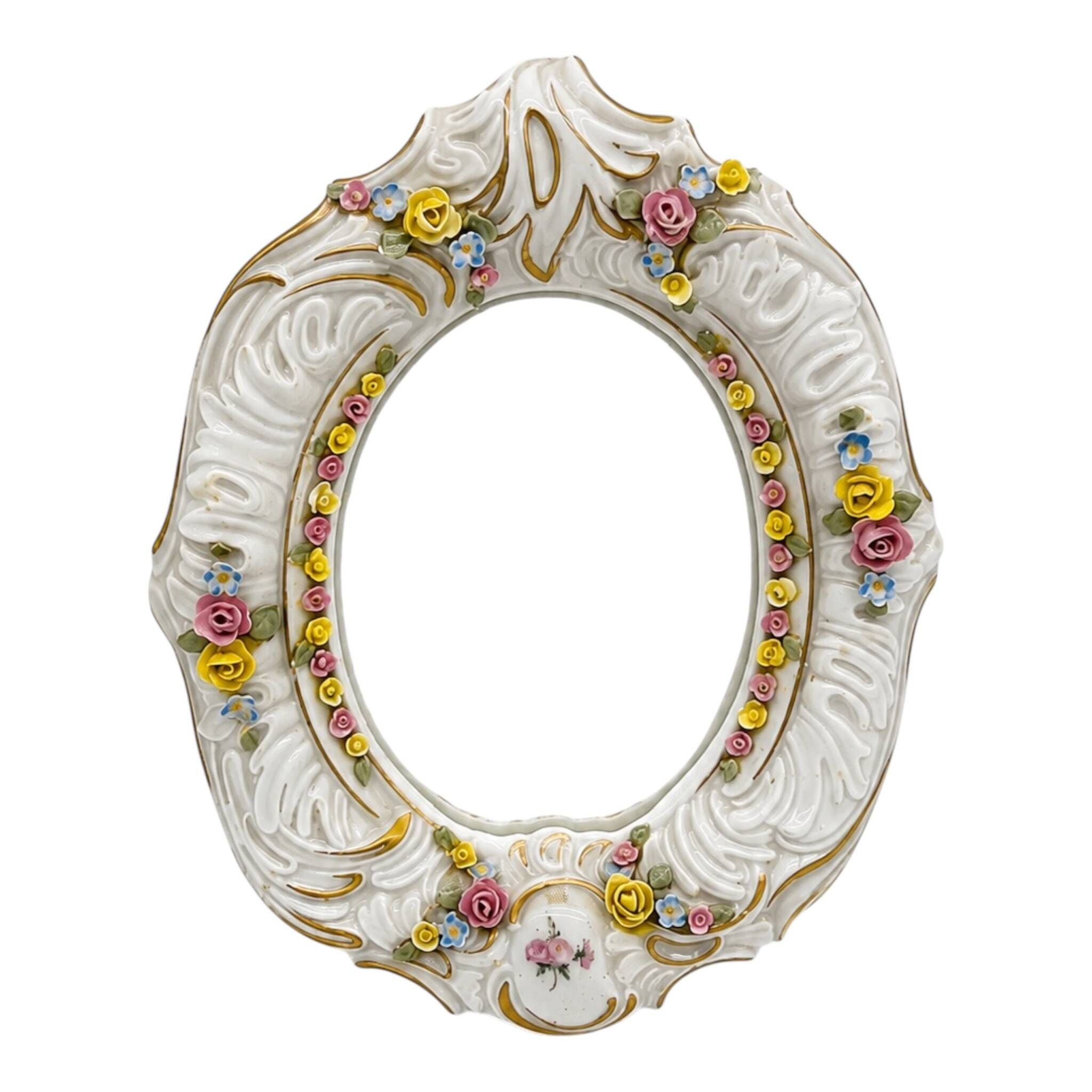 Antique porcelain mirror from Dresden with relief flowers and rococo decoration.