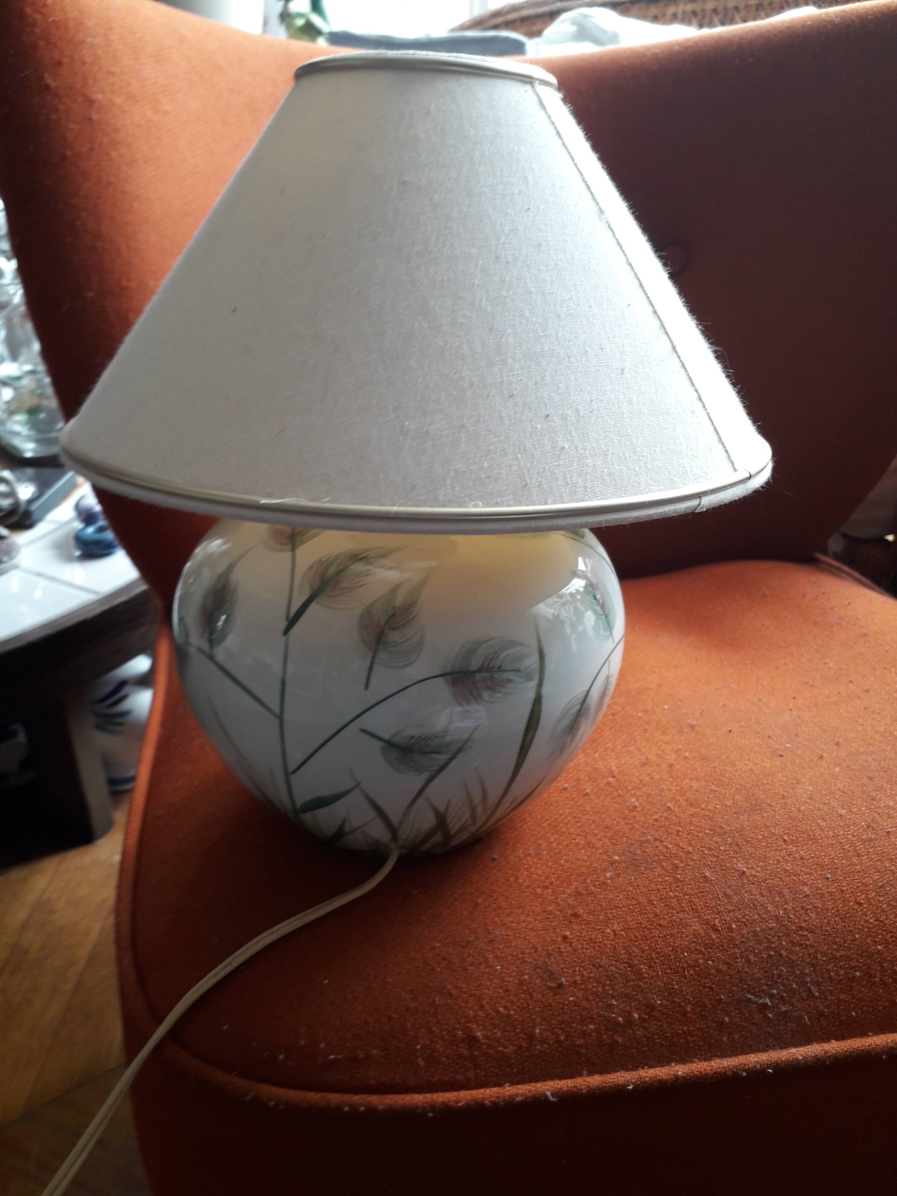 Antique ceramic lamp with a floral design.