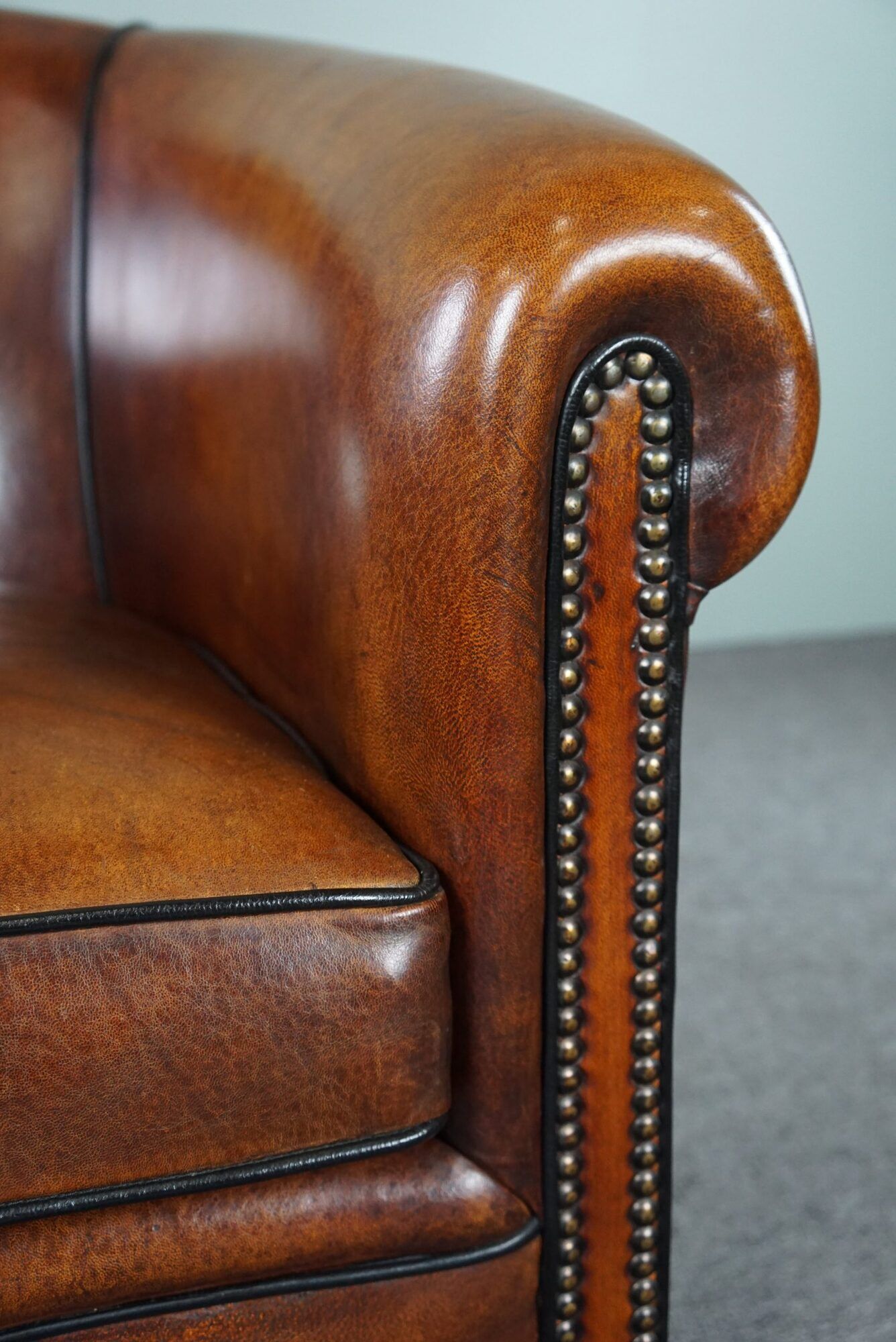 Club armchair in sheepskin with black piping