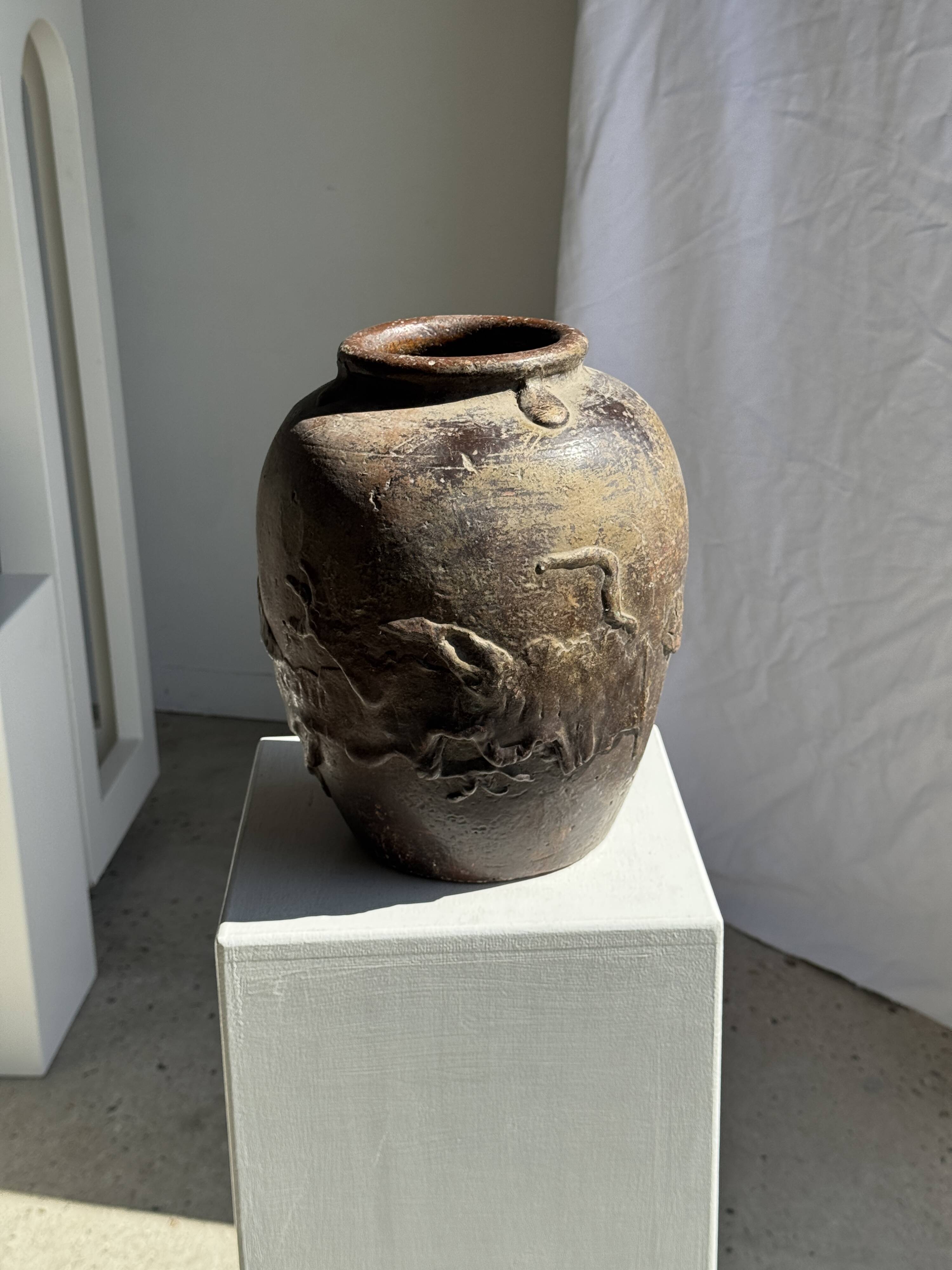 Large traditional Indonesian clay pot featuring a dragon.