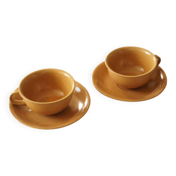 Set of 2 light brown stoneware tea cups and saucers.
