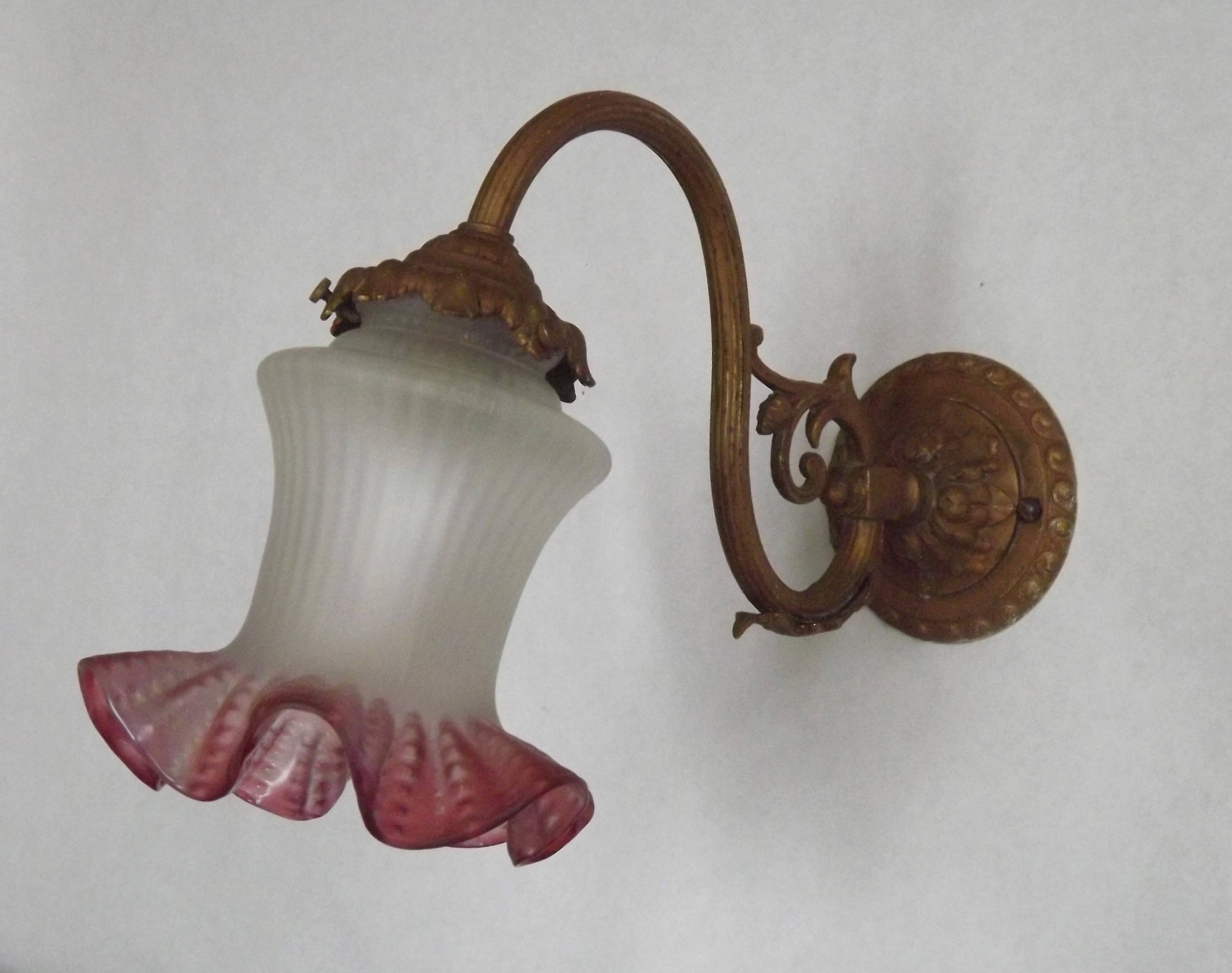 French Art Nouveau wall sconce in bronze with a white and pink glass shade.