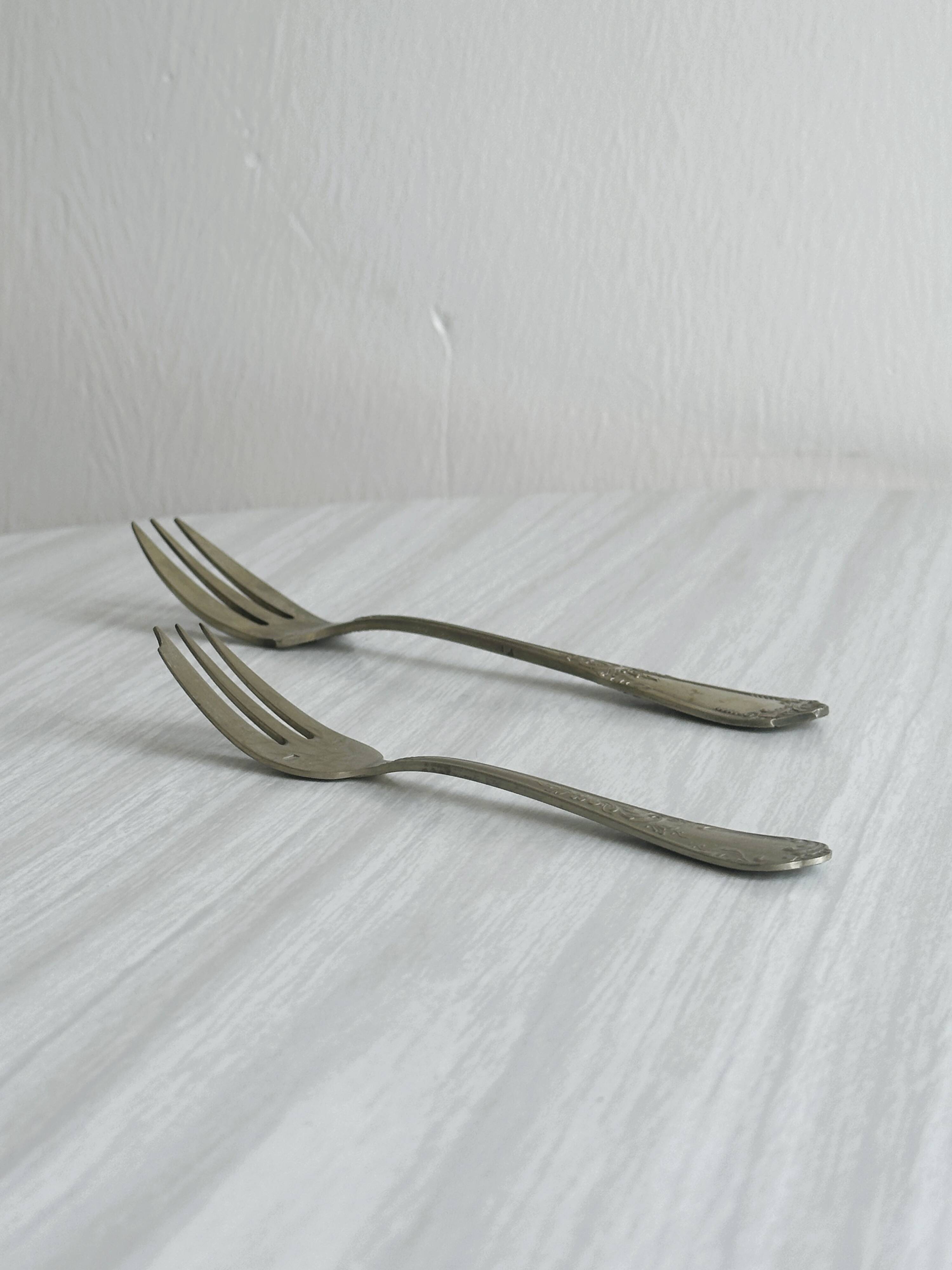 Paire de fourchettes en métal argenté, design orné