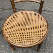 Vintage 19th-century bistro chair made of curved solid wood and caned in the Thonet style.