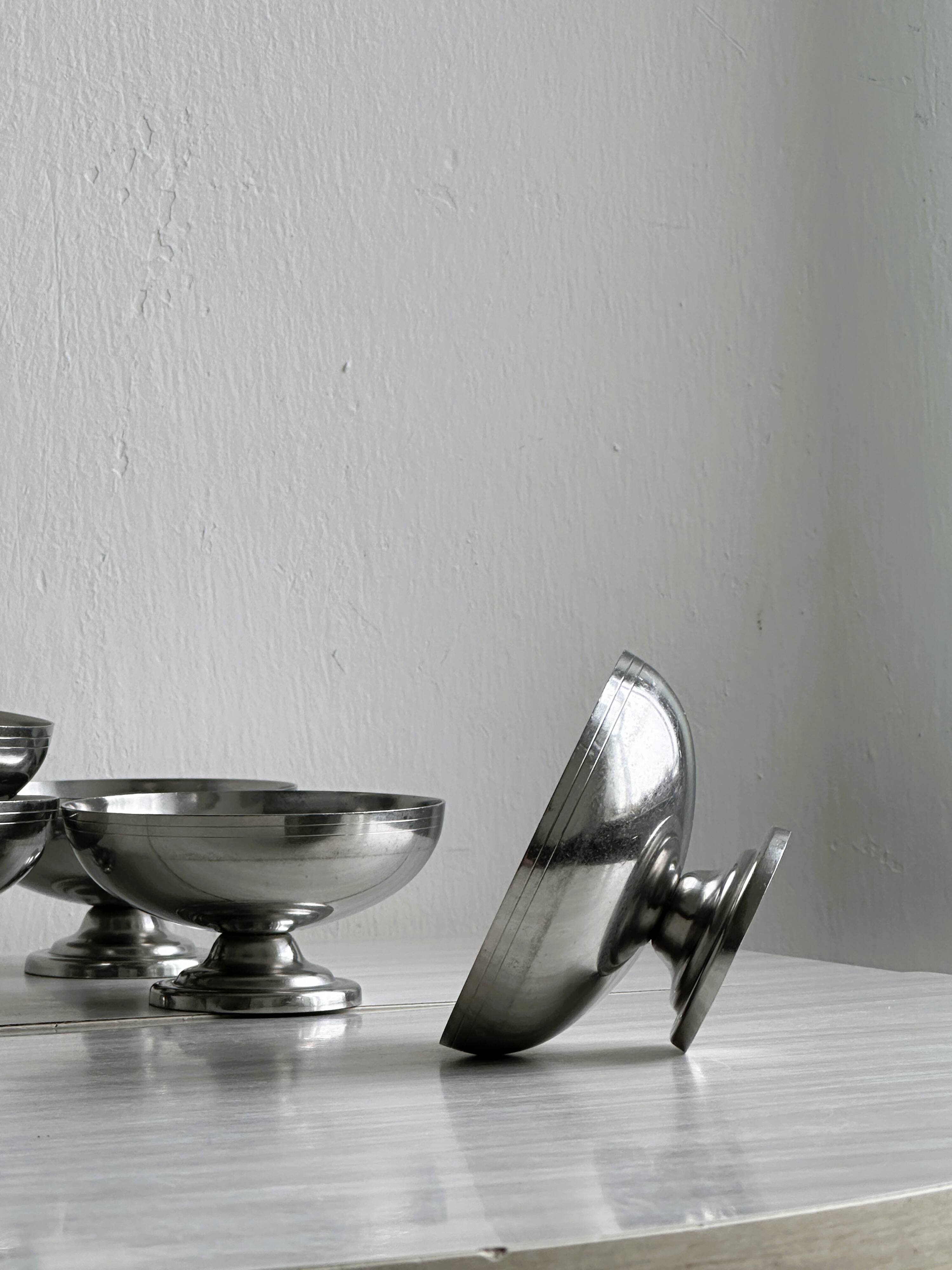 5 silver metal cups.