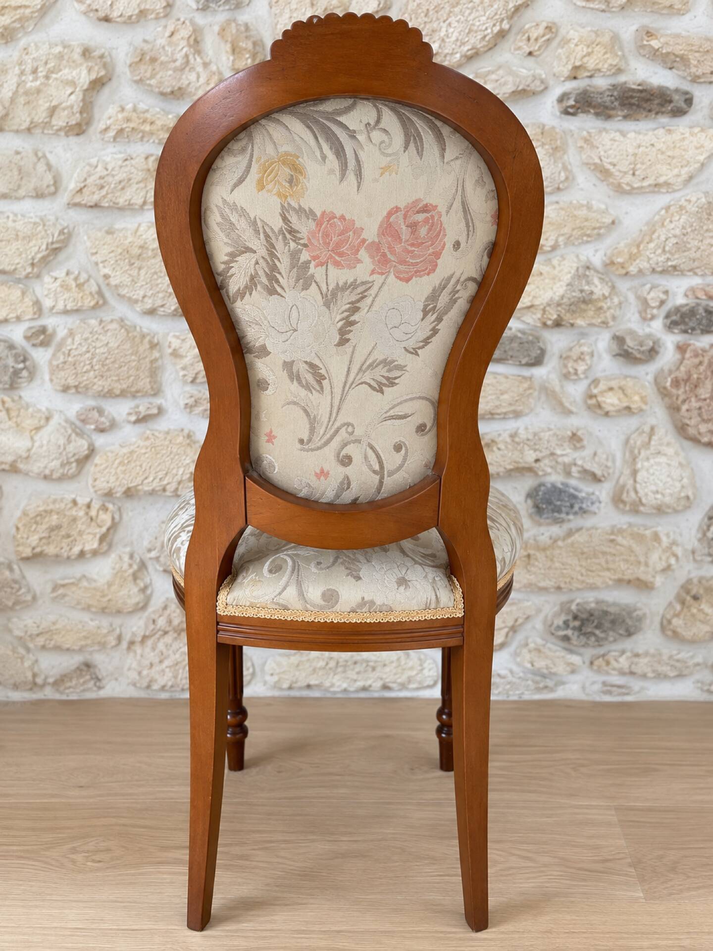 Antique Louis XVI style chair in wood and floral fabric.