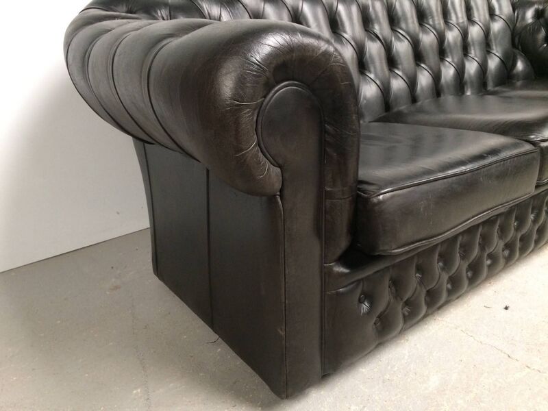 Three-seater black leather chesterfield sofa