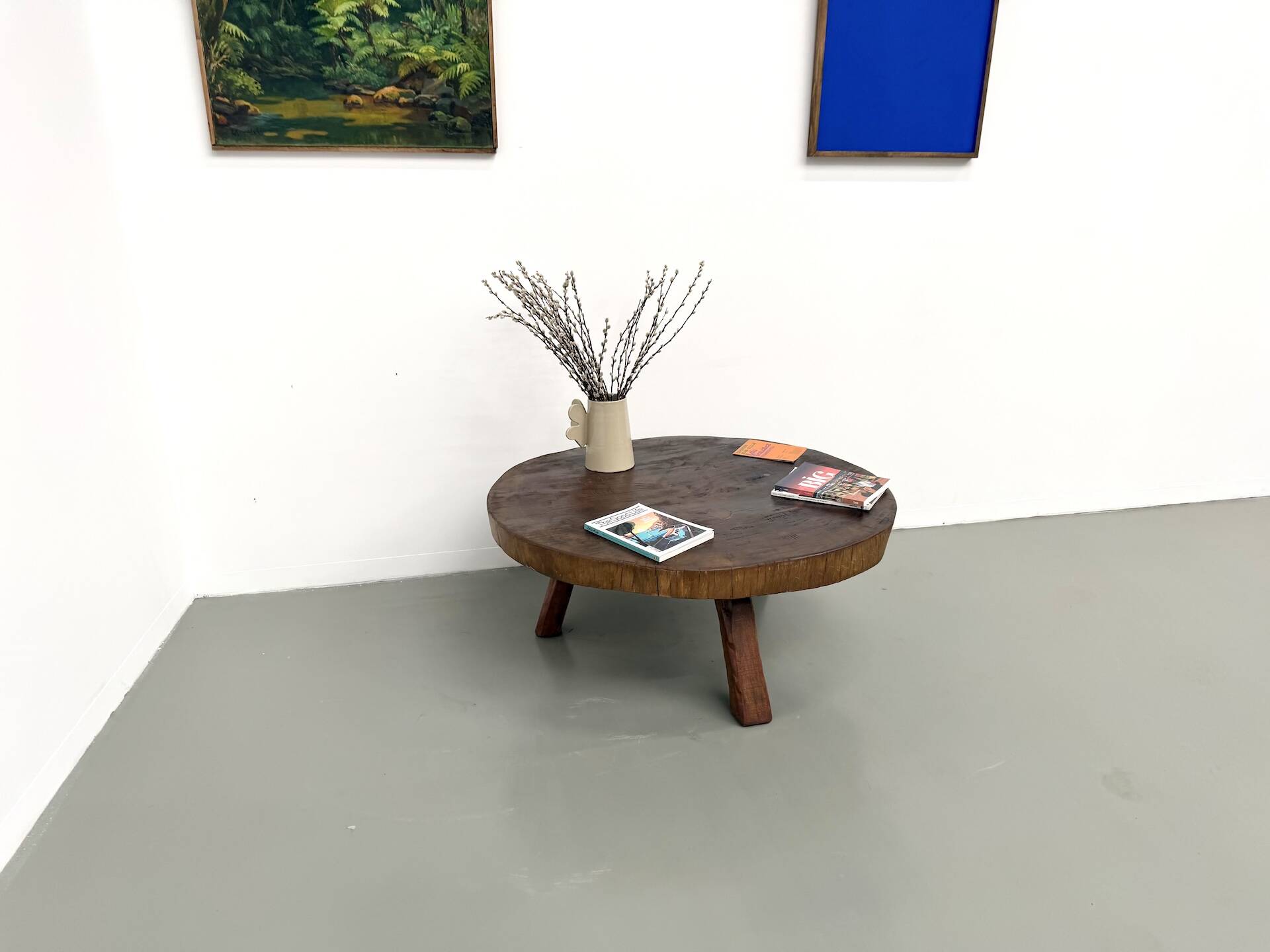 Brutalist coffee table in solid teak, monolithic slab, tripod base.