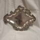 Old small silver-plated tray with a design of scrolls and leaves.