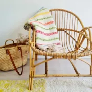 Moroccan plaid made of handwoven wool, decorated with stripes and pom poms.