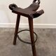 Set of 3 rustic carved oak bar stools with iron footrests, 1970s