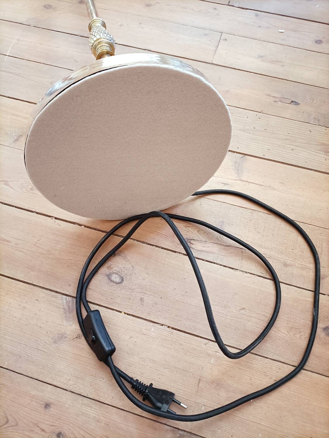 Bronze floor lamp with pine cone decoration.