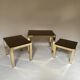 Set of three nesting side tables in brass and smoked mirror.