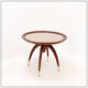 Round Art Deco side table in wood with curved legs and brass feet.