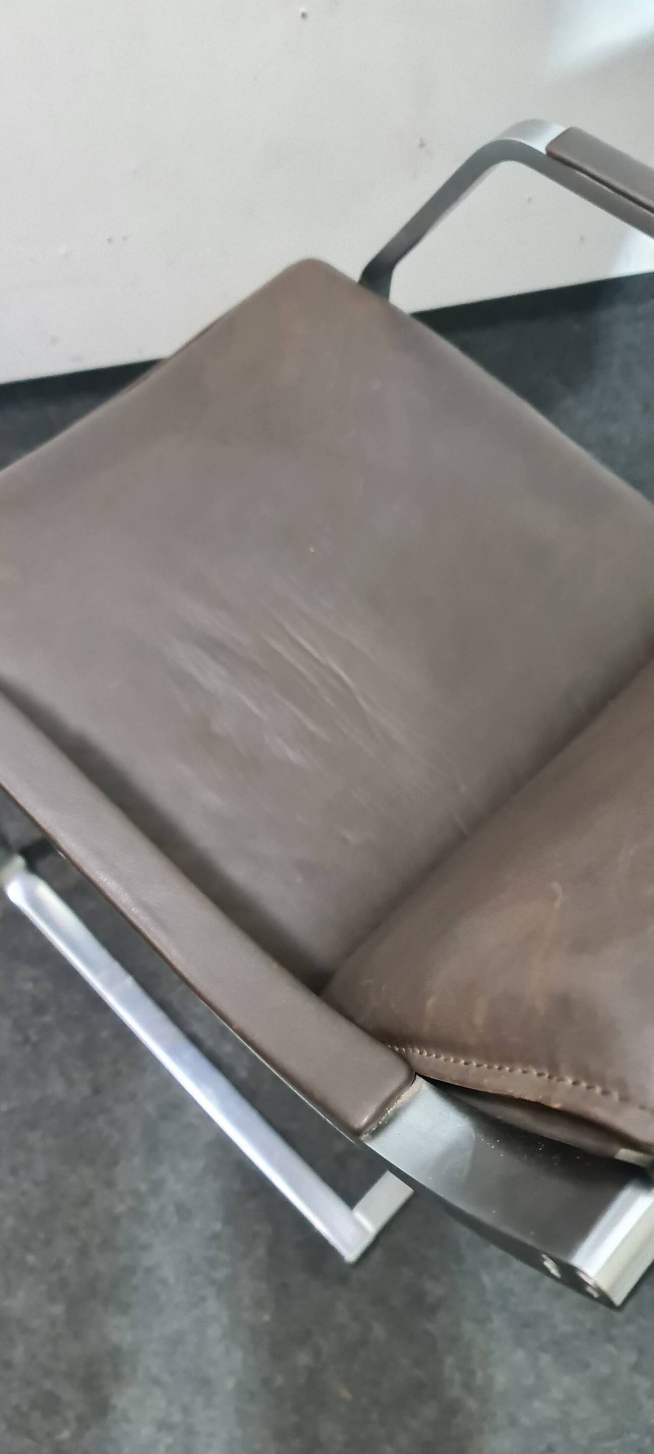 One of two vintage Leather and metal arm chairs.