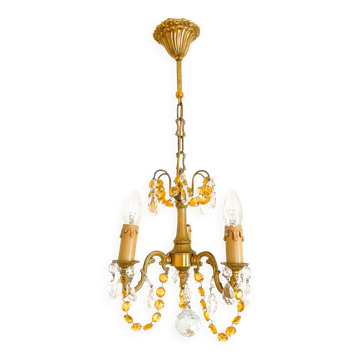 Small vintage brass chandelier with amber crystal pendants.