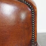 Sheepskin leather armchair in a cognac color with black piping