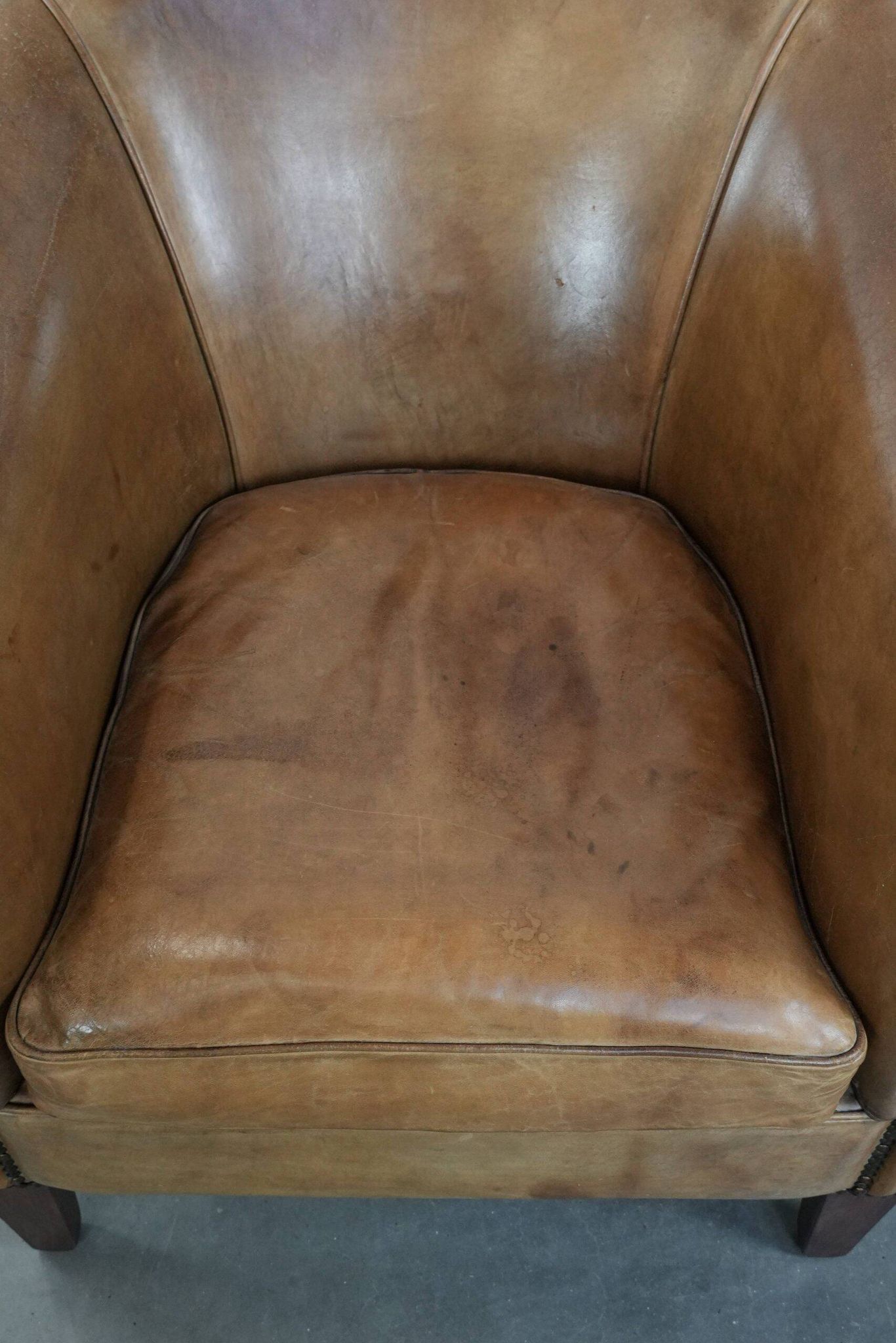 Characterful club chair made of sheepskin leather with light cognac colours