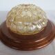 ceiling light with amber glass globe, on a round light wood base