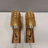 A set of wall lamps in teak wood, with amber colored glass