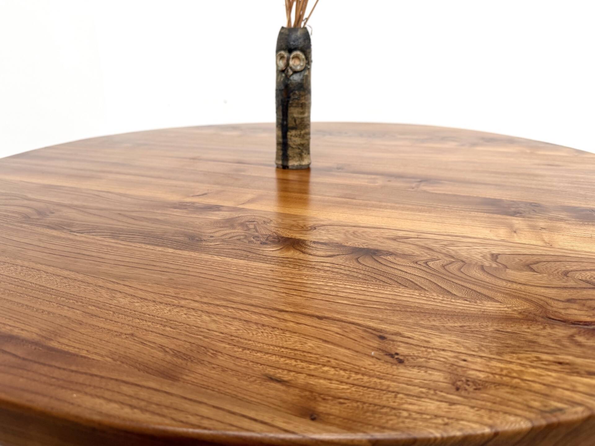 Modernist round table in solid elm, crossed legs.