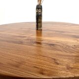 Modernist round table in solid elm, crossed legs.
