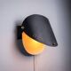 Matte black wall lamps with perforated shades and brass details