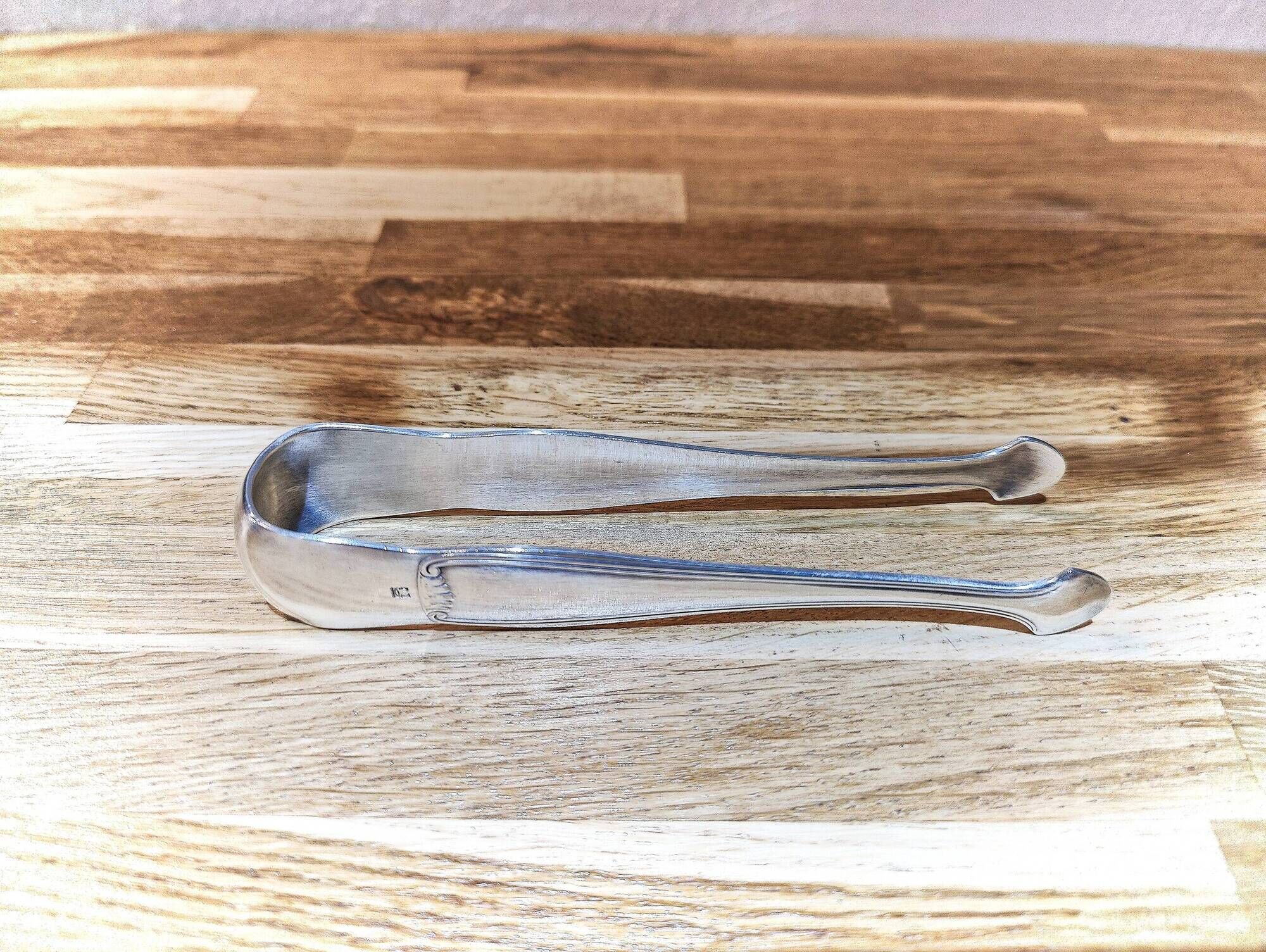 Antique sugar tongs in silvered metal