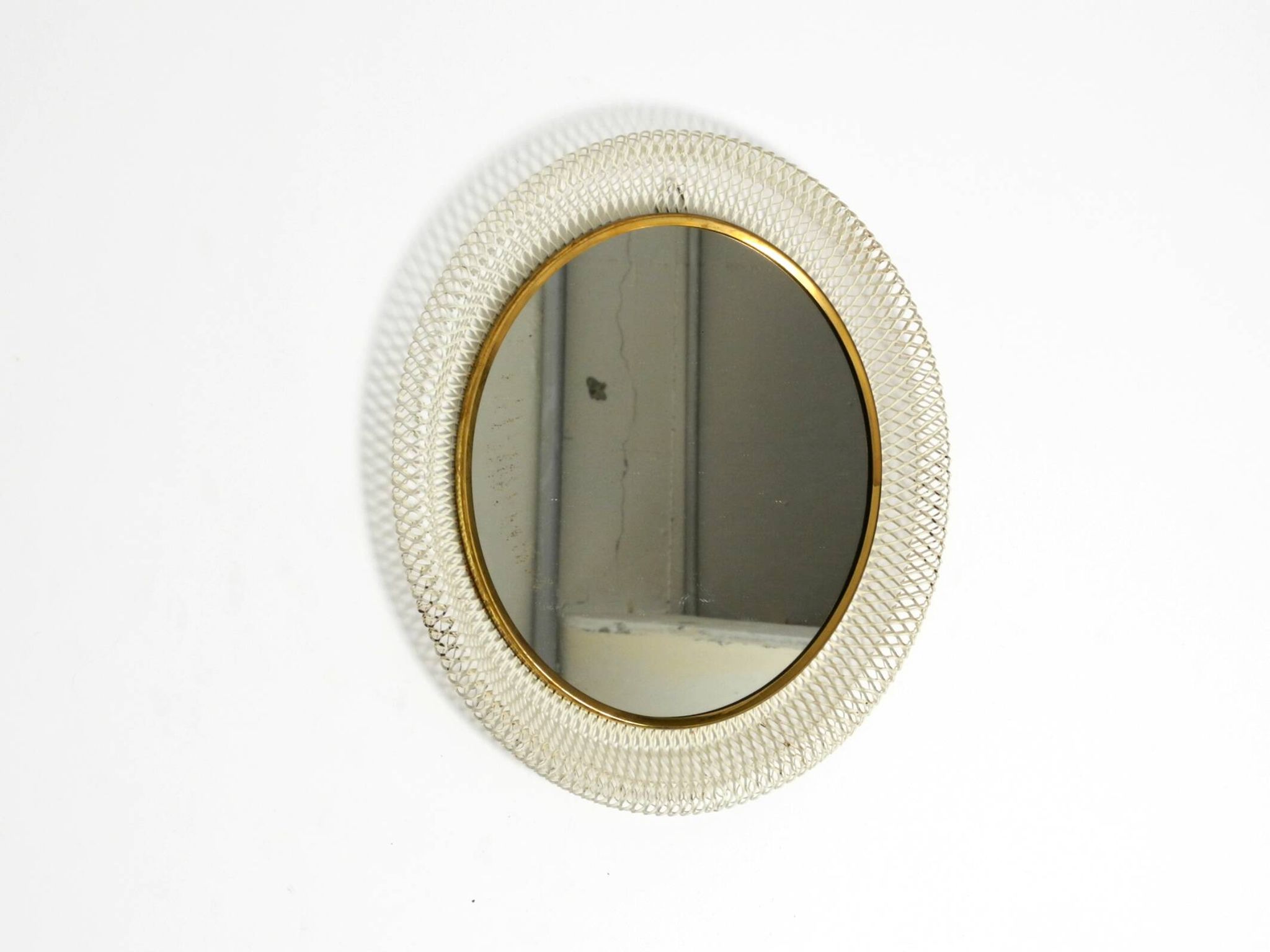 Miroir mural rond de style Mid-Century Modern avec un cadre en métal blanc expansé.