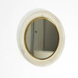 Mid Century Modern round wall mirror with a white expanded metal frame